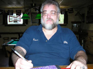 A close up of me sitting with pen in hand, while sitting at the bar, at Lisa's Lounge Looking out at you!